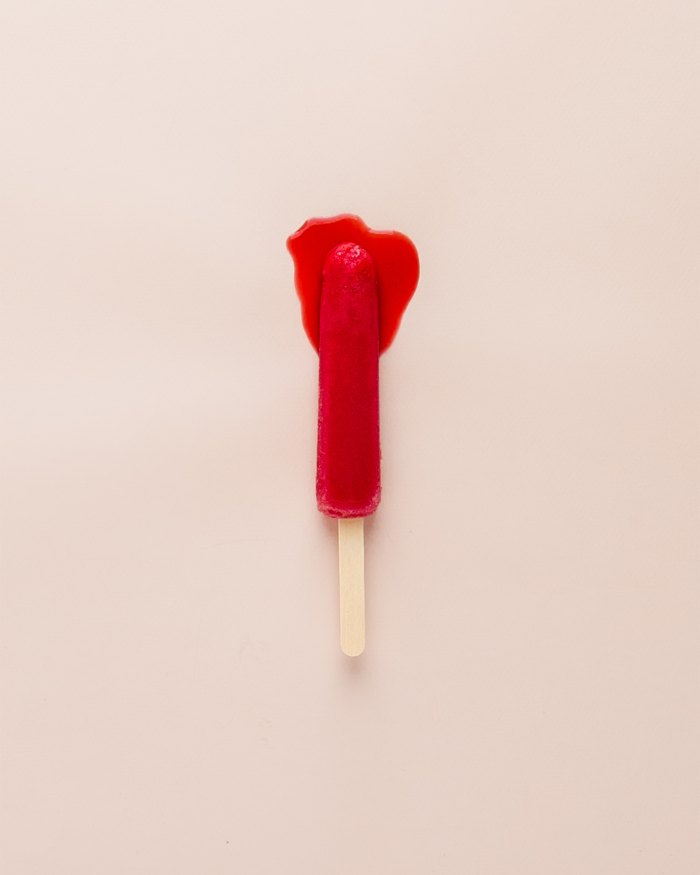 Image of a red popsicle/ice lolly melting